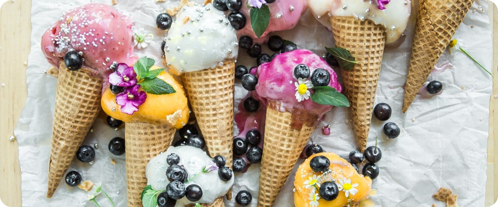 waffle cones with different types of ice cream decorated with
        blackberries