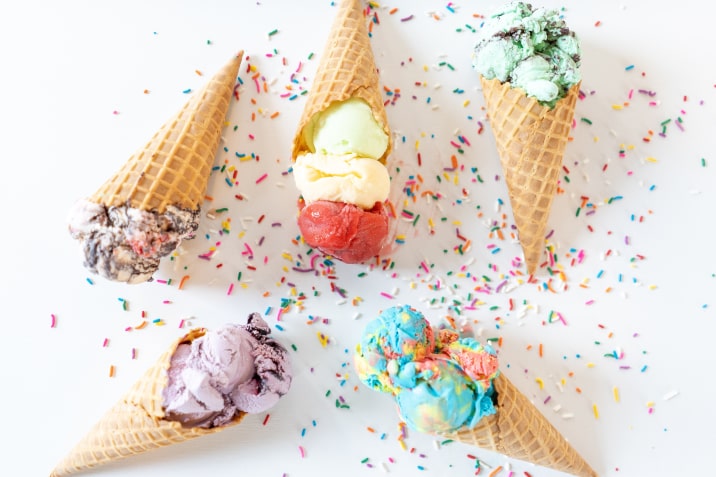 different types of ice cream in five waffle cones with decoration