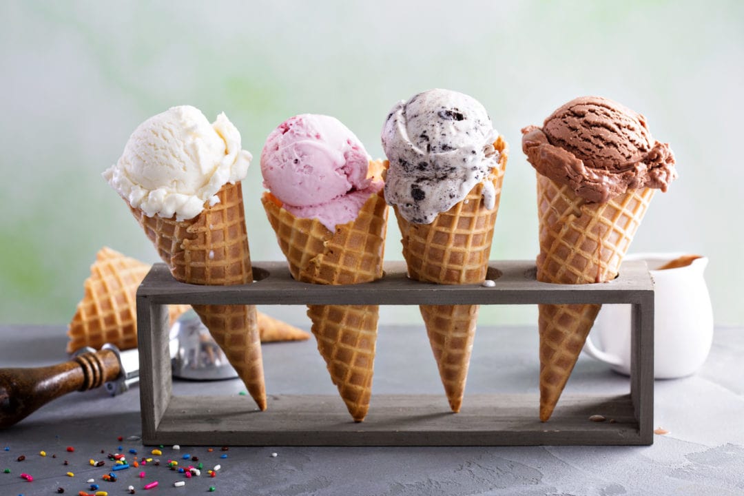 four different types of ice cream in waffle cones